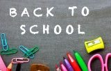 Back to school on chalkboard surrounded by school supplies